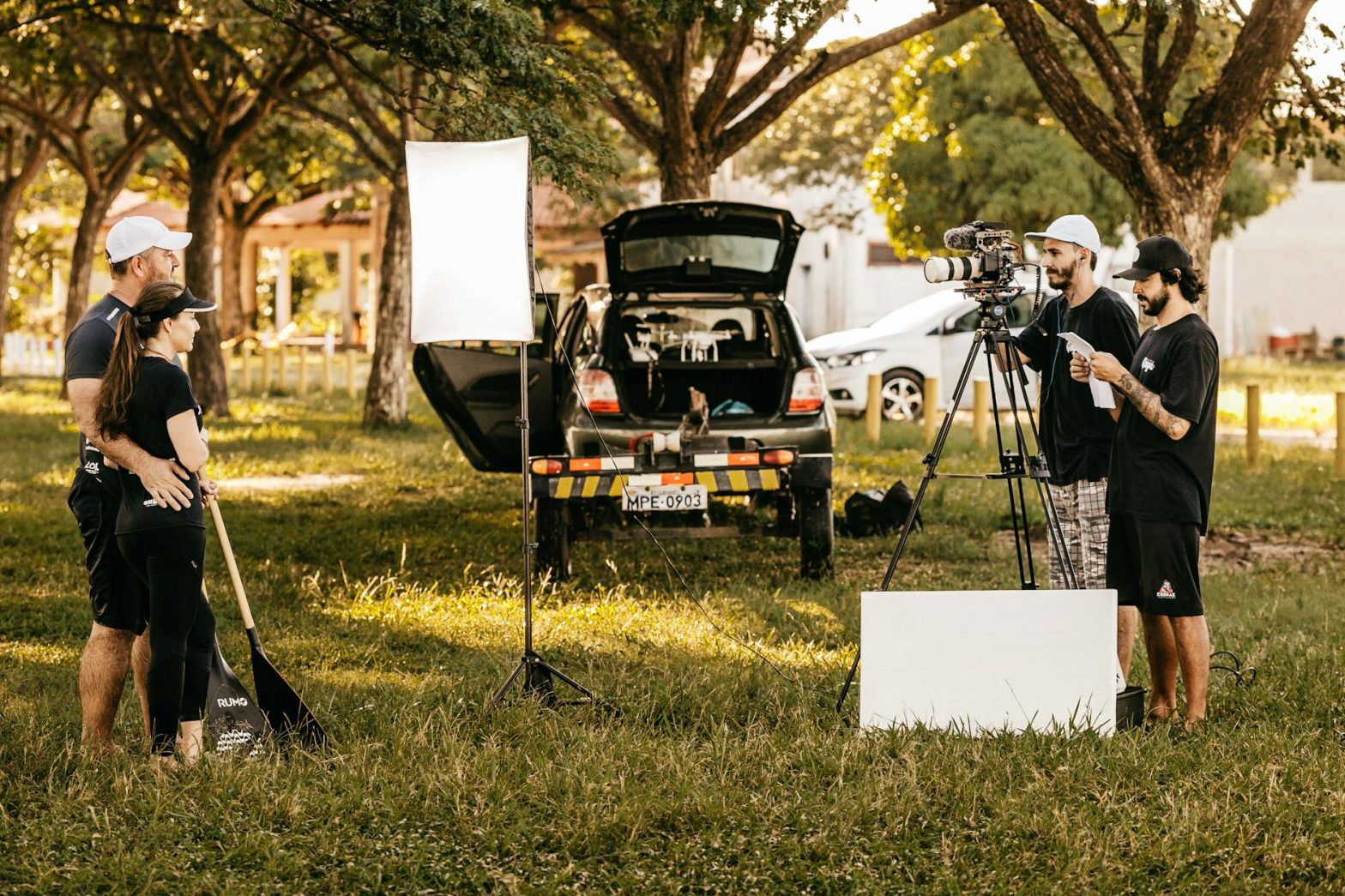 Film crew preparing for a shoot outdoors with gear and equipment.