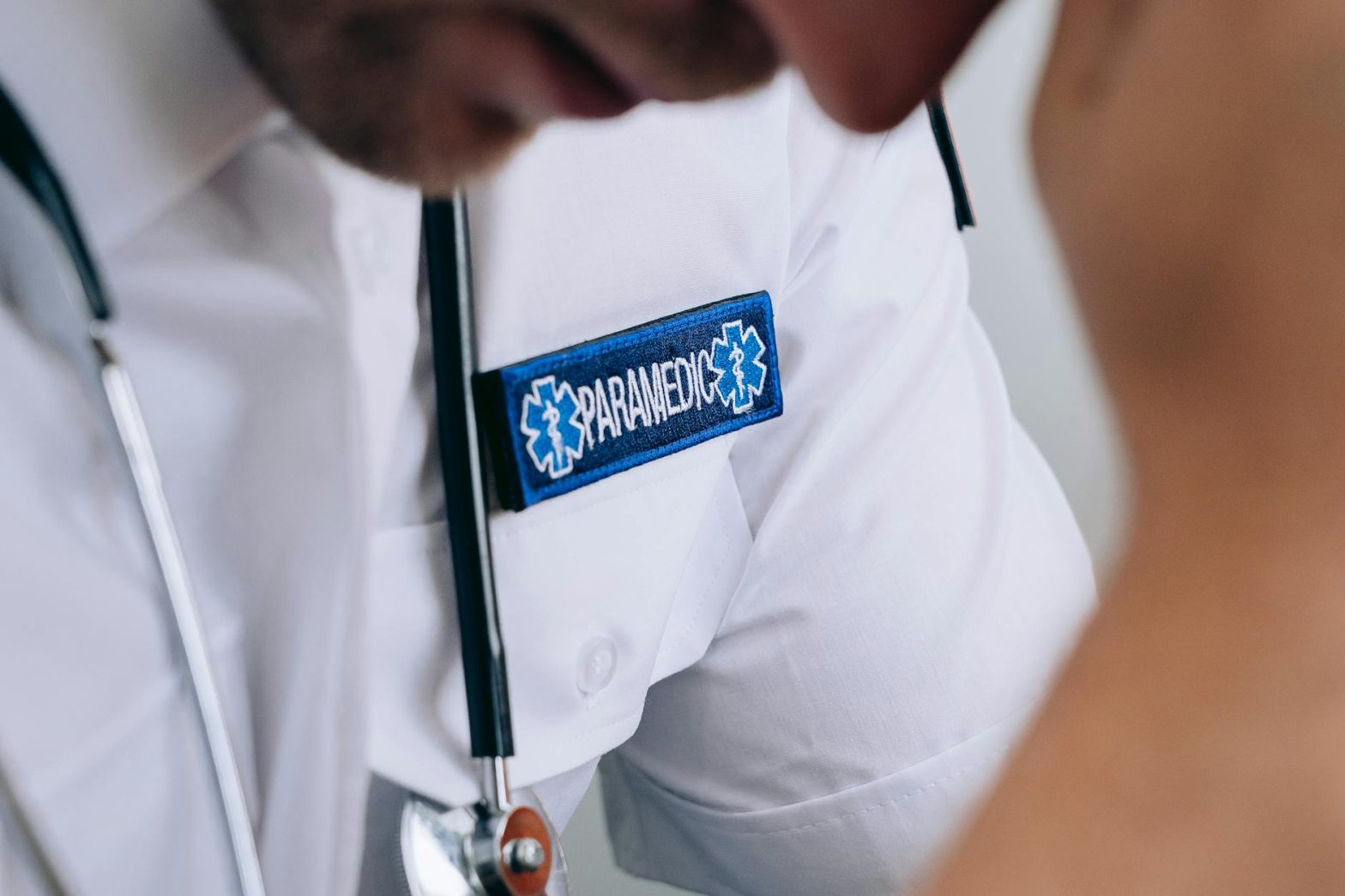Detailed shot of a paramedic in uniform, highlighting the badge and stethoscope.