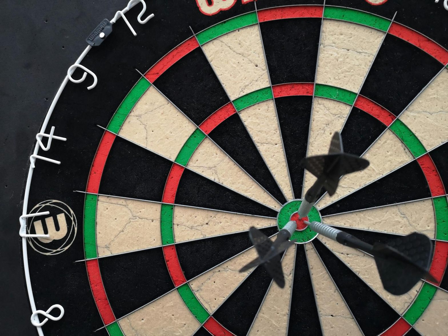 Precision-focused close-up view of darts hitting the bullseye on a dartboard.