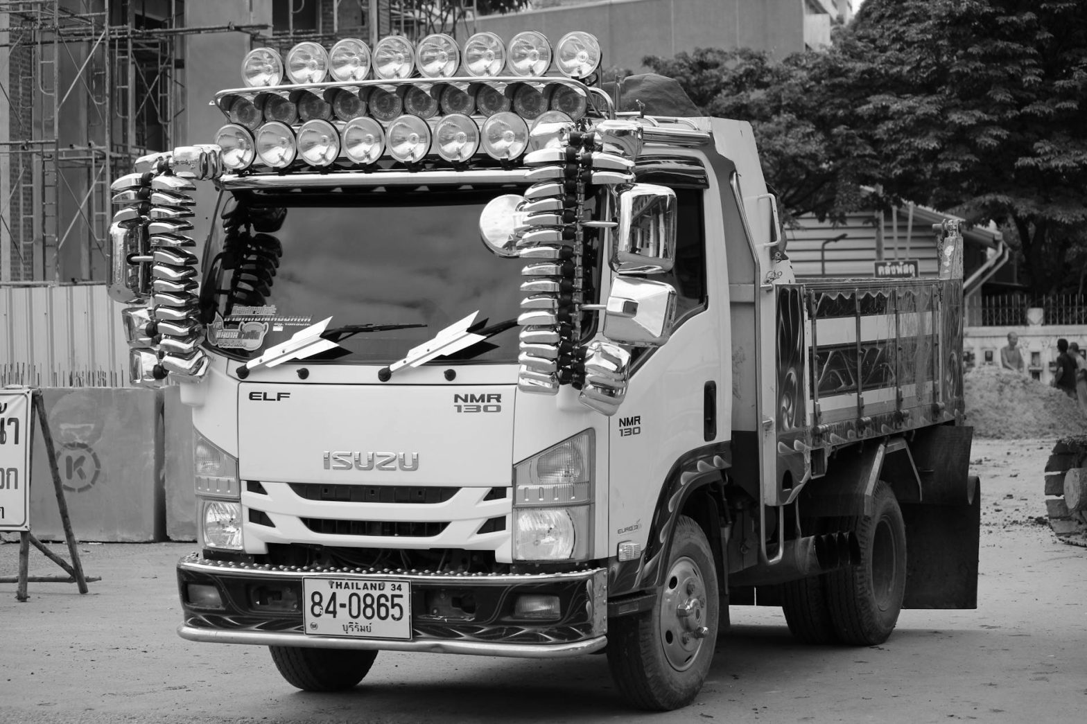Unique truck with custom lights and mirrors parked in urban area, showcasing cultural style.